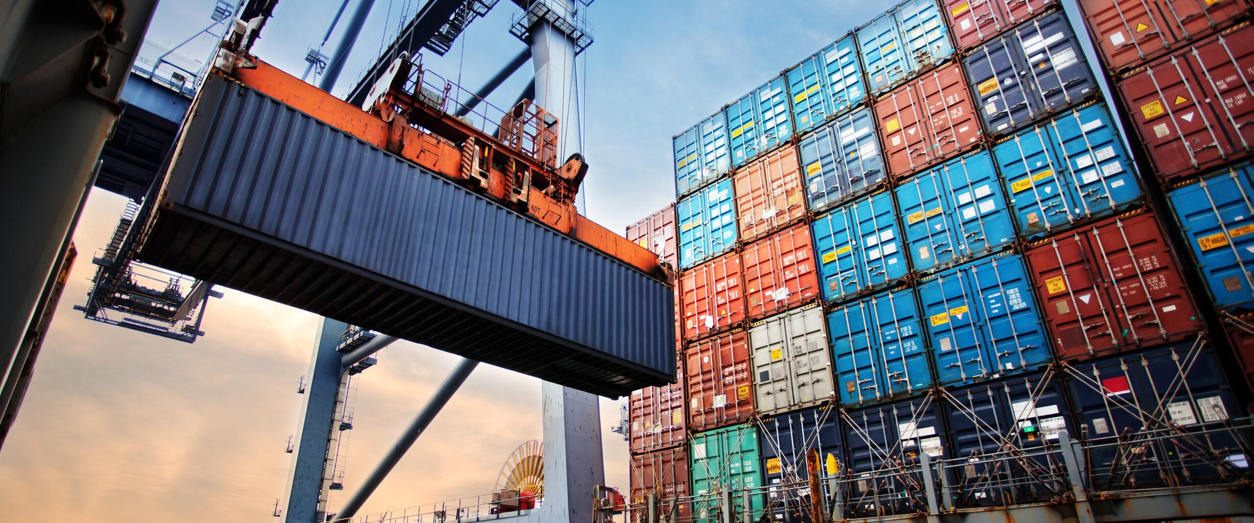 Gantry cranes lifting containers at a port (Japan to Piraeus, 40HC ocean freight)